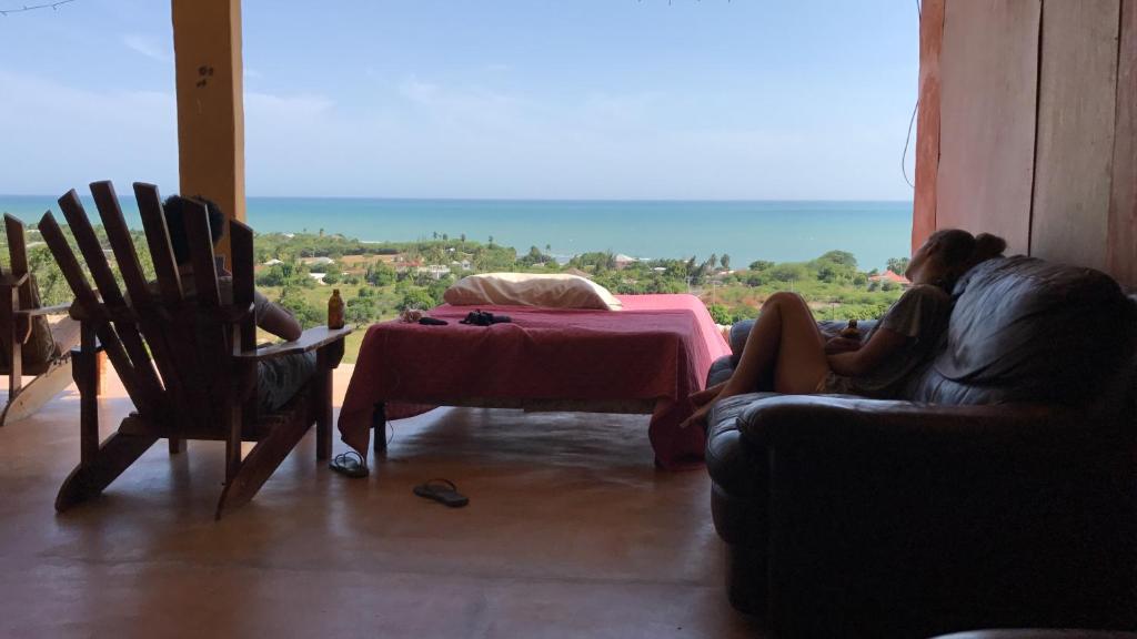 瑰寶海灘的住宿－歡迎瓦布斯旅館，坐在一张桌子的房间的沙发上的女人