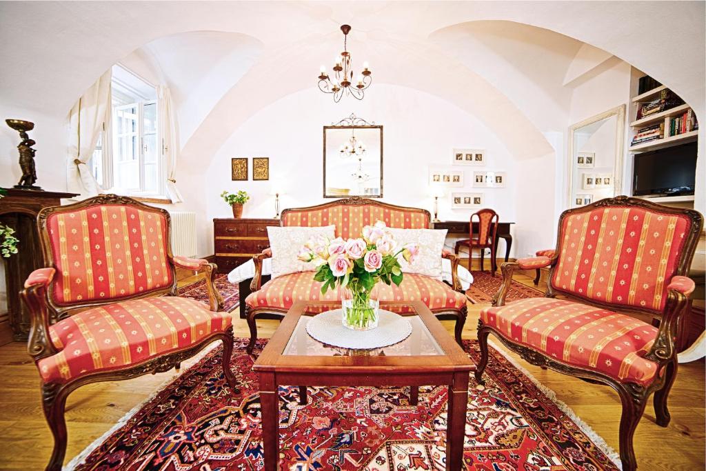 salon z 2 krzesłami i stołem z wazonem kwiatów w obiekcie Salzburg Place to Stay w mieście Salzburg