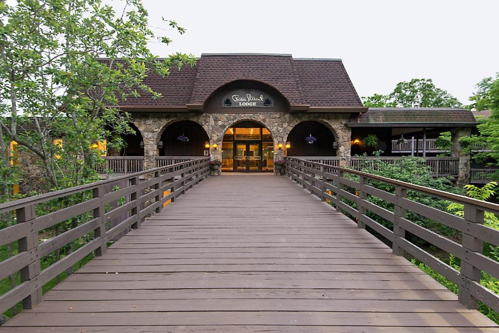 un puente de madera que conduce a un edificio con puerta en Greenbo Lake State Resort Park en Argillite
