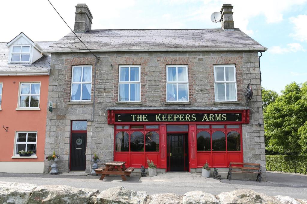 un bâtiment rouge avec un panneau d'armoiries de détenteurs dans l'établissement The Keepers Arms, à Ballyconnell