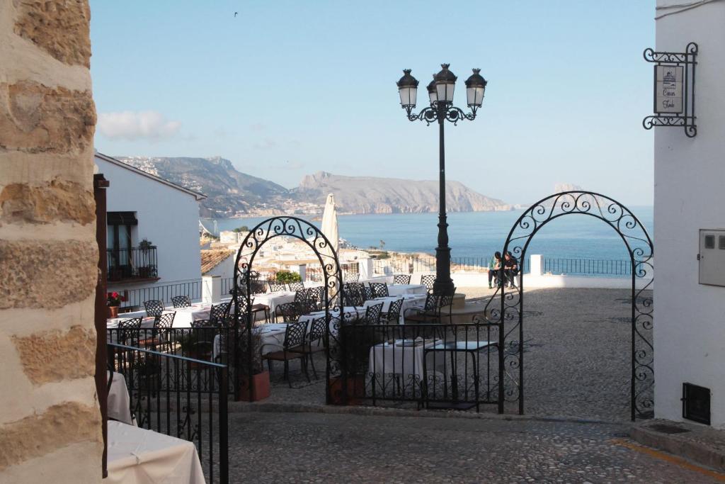 un patio con mesas, luz de la calle y el océano en Casa con encanto en Altea, en Altea