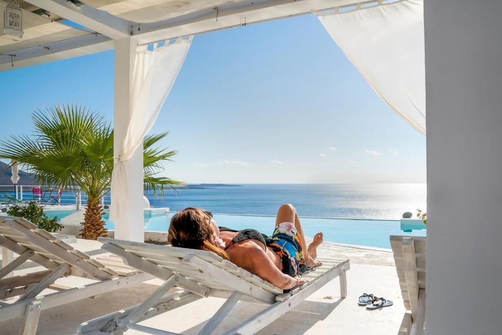 a man and woman laying on a hammock on the beach at Kaladi Rock in Avlemonas