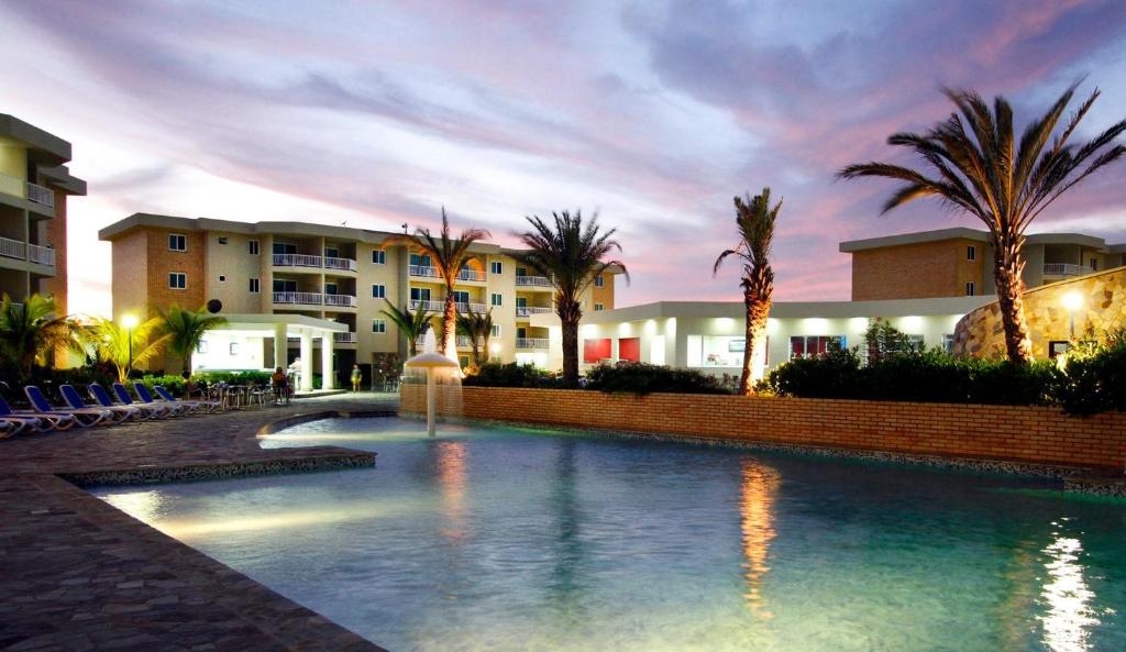 a swimming pool with a fountain in front of a building at LD Suites Punta Playa in Altagracia