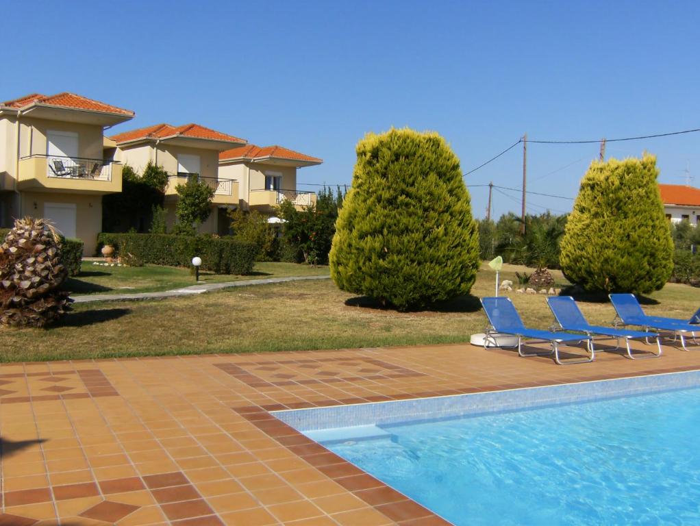 a couple of blue chairs sitting next to a swimming pool at Villa Potidea Panorama in Nea Potidaea