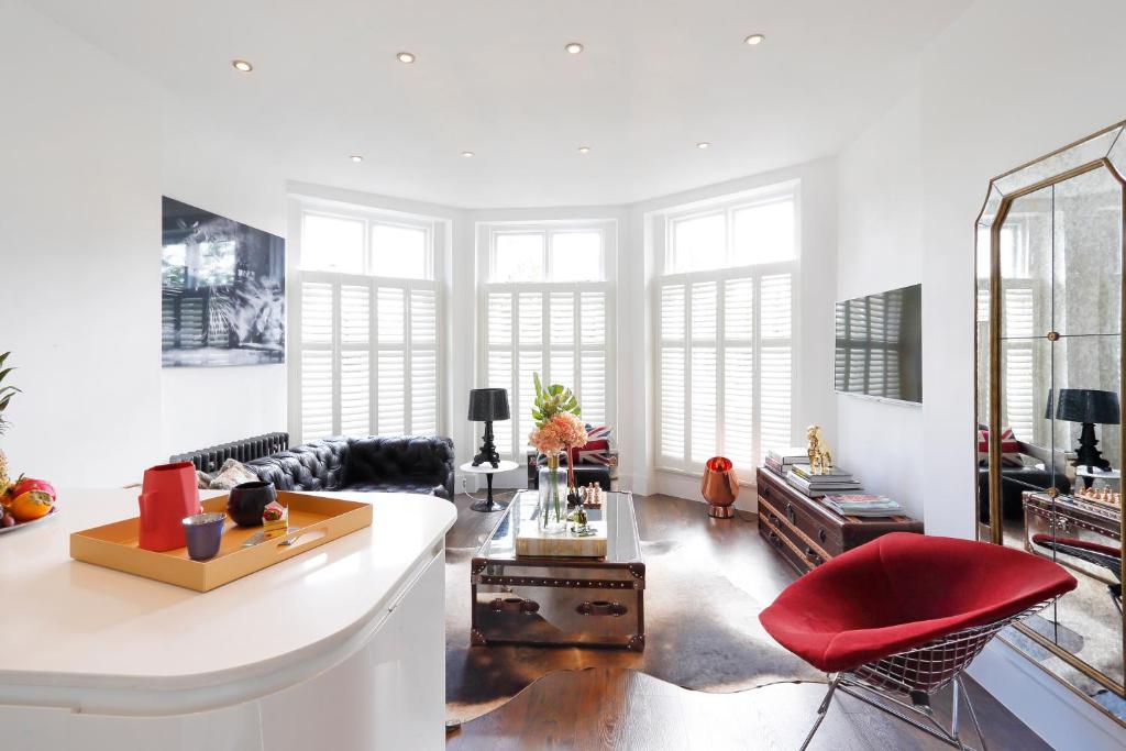 a living room with a couch and a red chair at Primrose Boutique Home in London