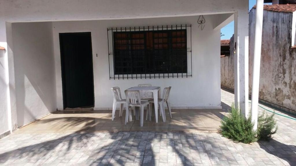 - une table et des chaises sur la terrasse couverte d'une maison dans l'établissement Casa Próxima à Praia Da Cocanha, à Caraguatatuba