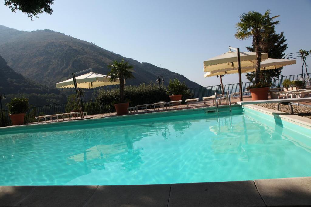 uma grande piscina com uma montanha ao fundo em Hotel & Spa Villa del Mare - Adult Only em Maratea