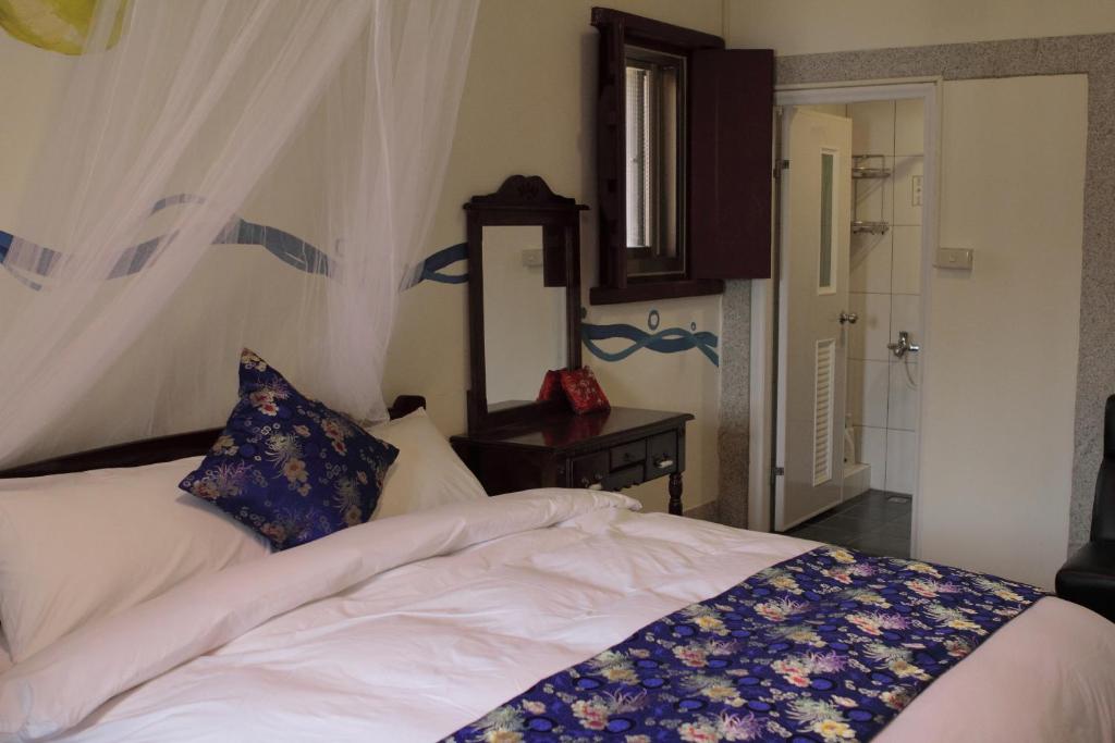 金寧鄉的住宿－雙鯉風晴古厝民宿，一间卧室配有一张带梳妆台和镜子的床