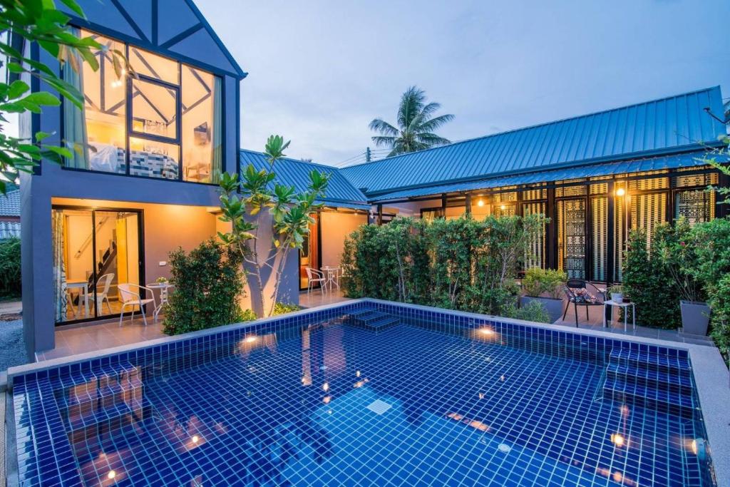 a house with a swimming pool in front of it at Villa Na Pran, Pool Villa in Pran Buri