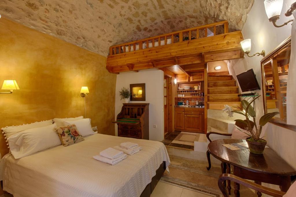 1 dormitorio con 1 cama y 1 mesa en una habitación en Dorovinis Monemvasia Castlehouses, en Monemvasia