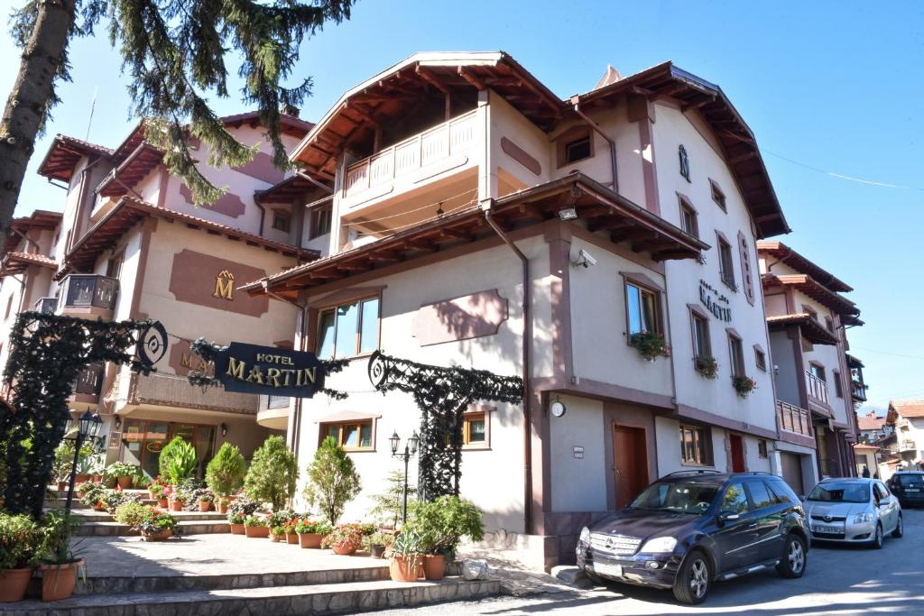 ein Gebäude mit einem davor geparkt in der Unterkunft Martin Club Hotel in Bansko