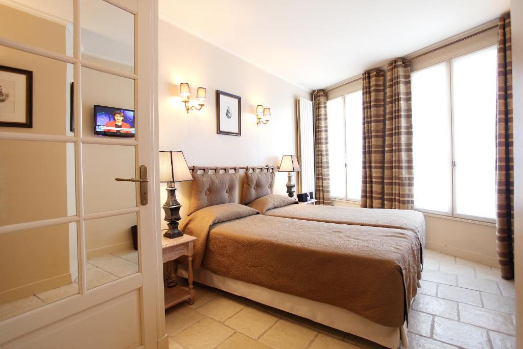 a hotel room with a bed and a window at Hotel Albe Bastille in Paris