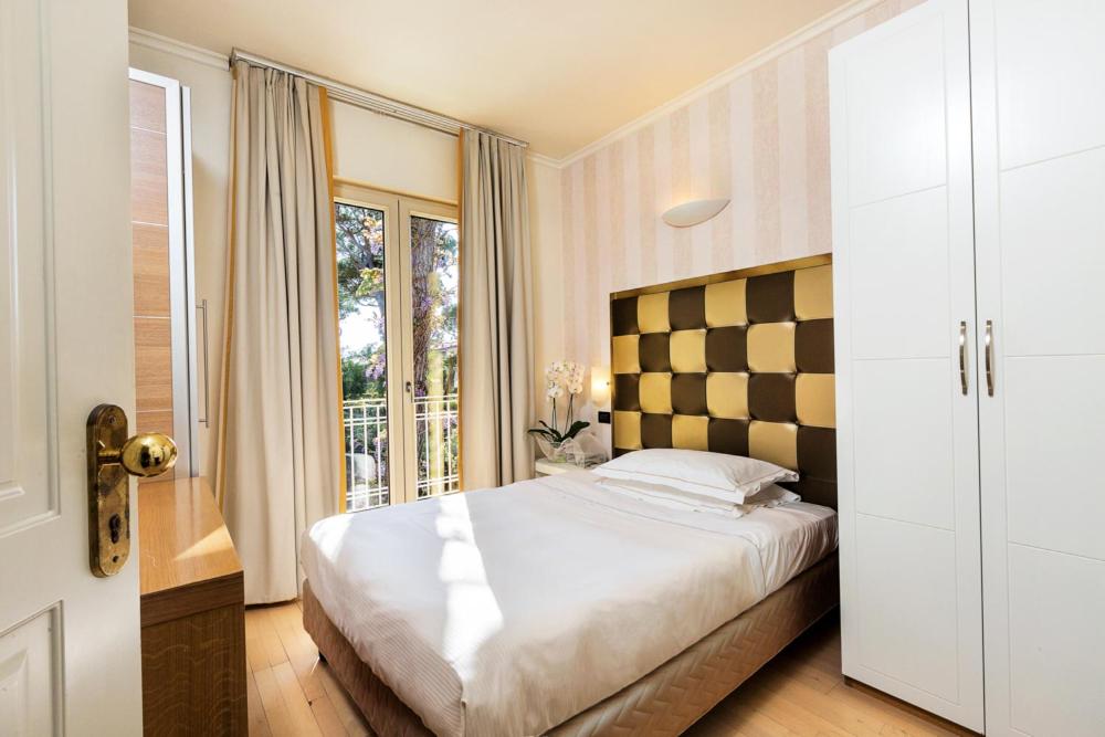 Postel nebo postele na pokoji v ubytování JR Resort Logos Forte dei Marmi