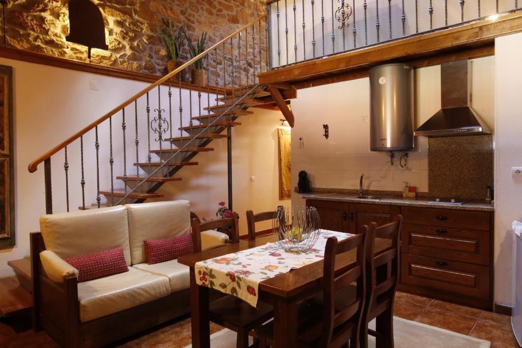 a kitchen with a dining room table and a staircase at Casas do Juizo - Country Houses in Juizo