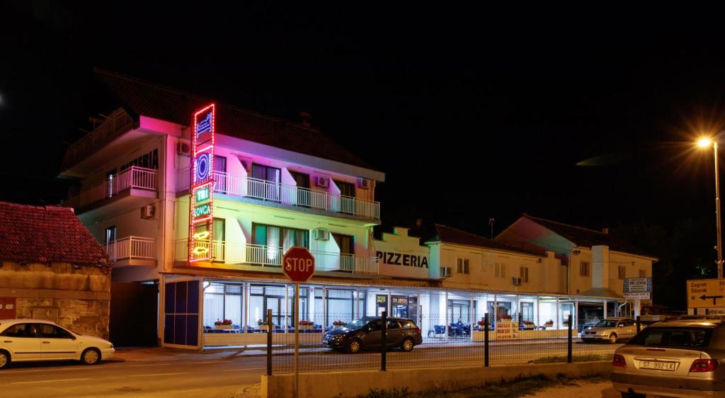 a brightly lit building with a stop sign in front of it at Motel "Tri lovca" in Knin