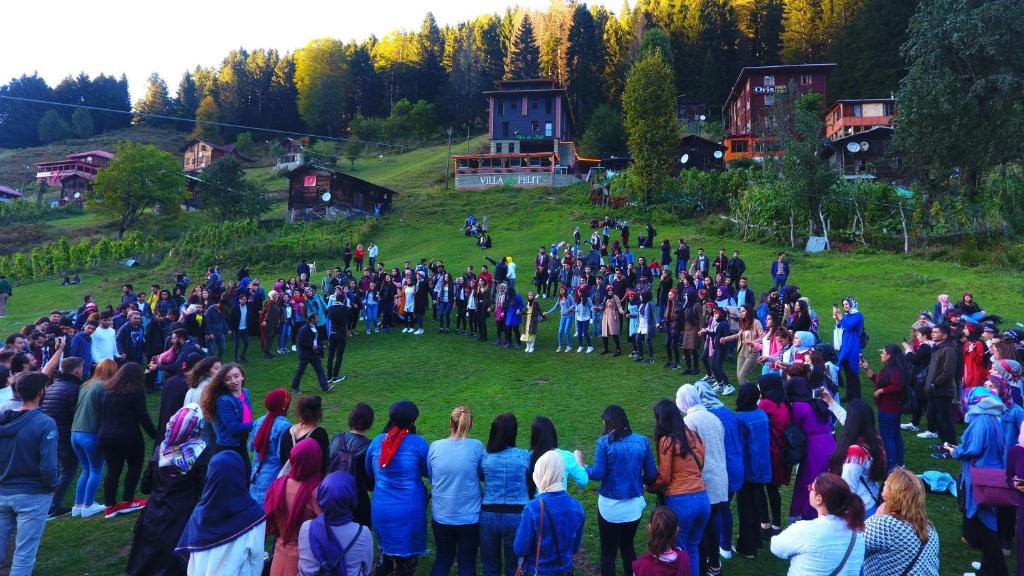 a large crowd of people standing in a field at Ayder Villa de Pelit Hotel in Ayder Yaylasi