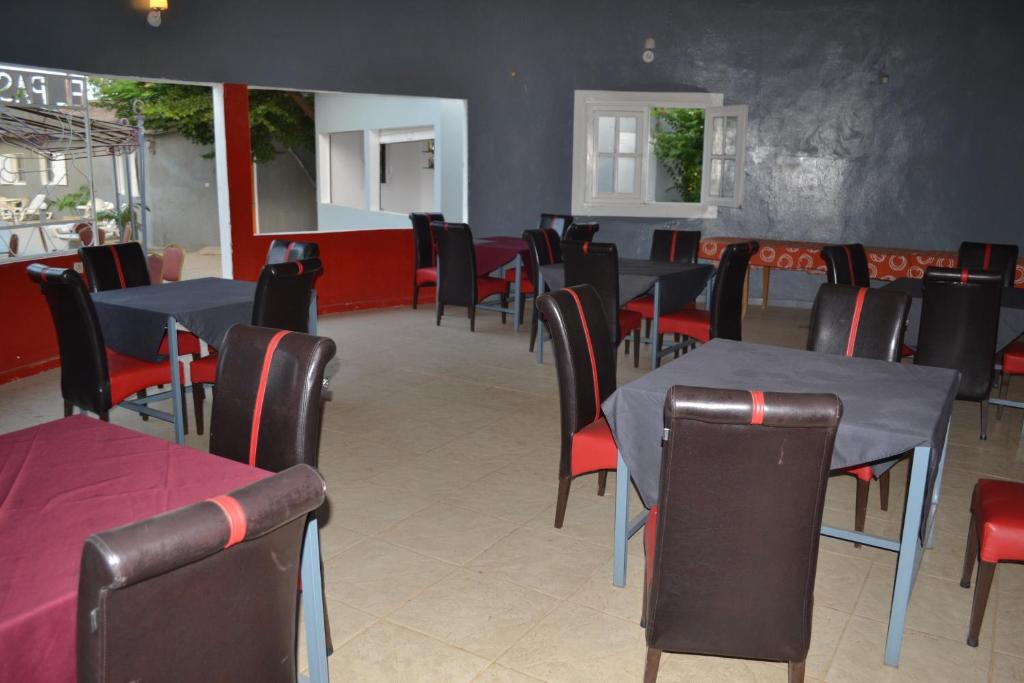 a dining room with blue tables and red chairs at Melia Hotel in Saly Portudal