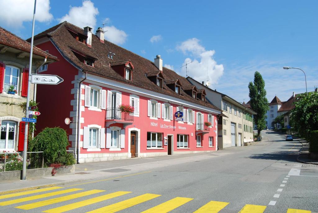 une rue avec des bâtiments rouges et blancs sur une route dans l'établissement Hotel-Rotisserie La Tour Rouge, à Delémont