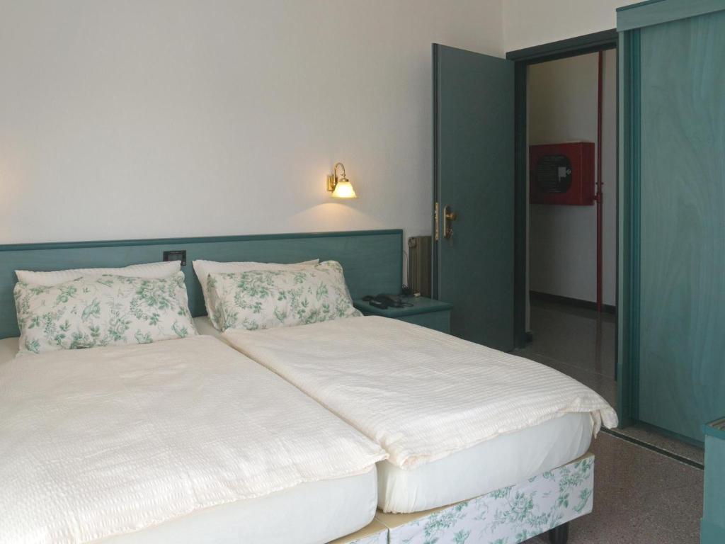 a bedroom with a large white bed with pillows at Hotel Flora in Celle Ligure