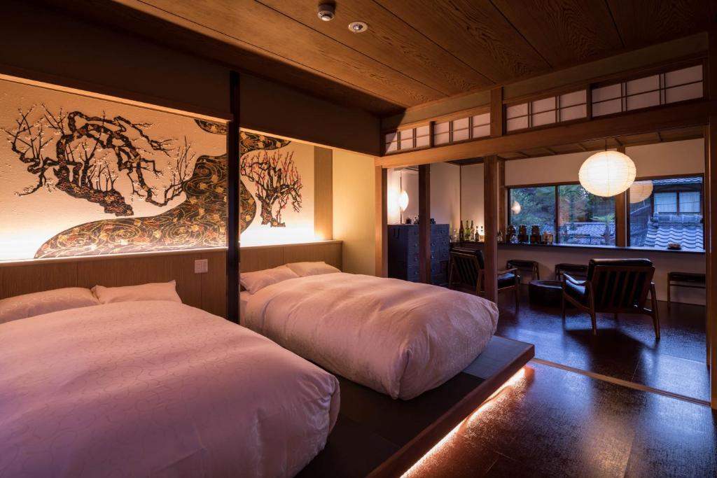 a bedroom with two beds and a dining room with a table at Kiraku Kyoto Higashiyama in Kyoto