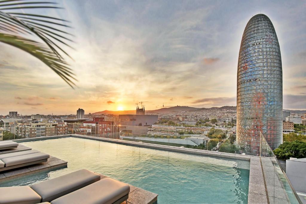 ein Pool auf dem Dach eines Gebäudes mit einem Wolkenkratzer in der Unterkunft Hotel SB Glow Sup in Barcelona