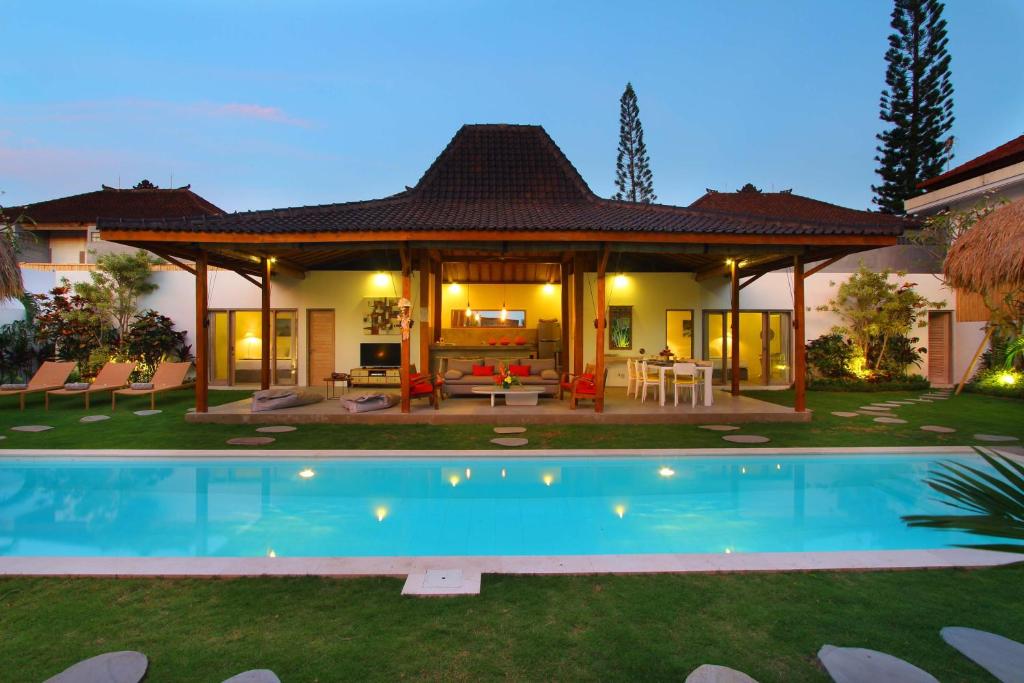 een huis met een zwembad in de tuin bij Villa Thiara by Optimum Bali Villas in Seminyak