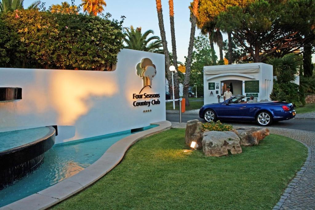 une voiture bleue garée devant un garage dans l'établissement Four Seasons Country Club, à Quinta do Lago