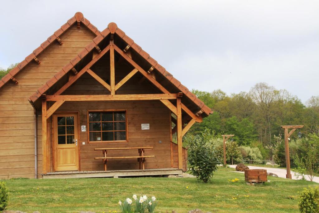une cabane en rondins avec un banc de pique-nique dans la cour dans l'établissement Le Hameau des Grilles, à Saint-Fargeau