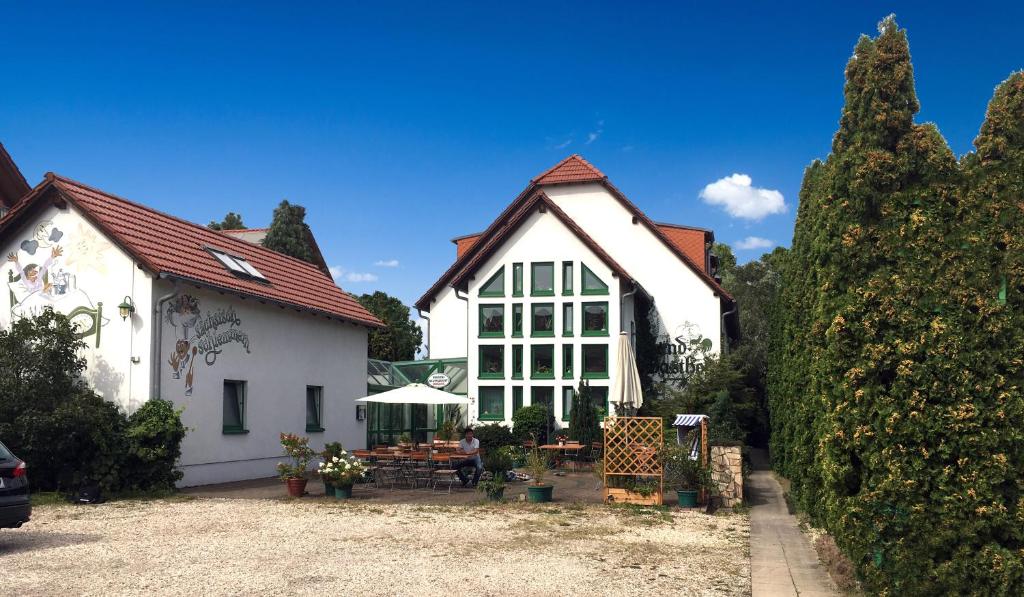 duży biały dom z ogrodem przed nim w obiekcie Hotel Lindenthal w Lipsku