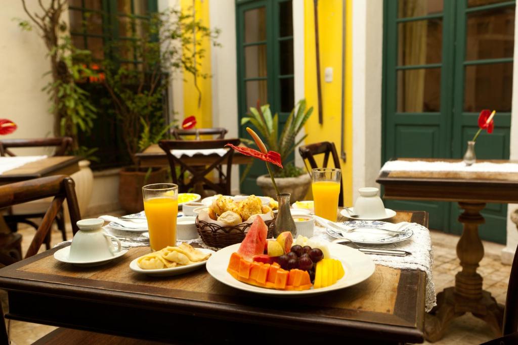 uma mesa com pratos de comida e sumo de laranja em Hotel Villa Bahia em Salvador