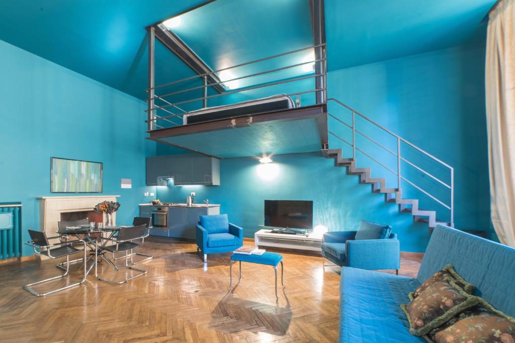 a living room with blue walls and a staircase at Loft Vasari in Florence