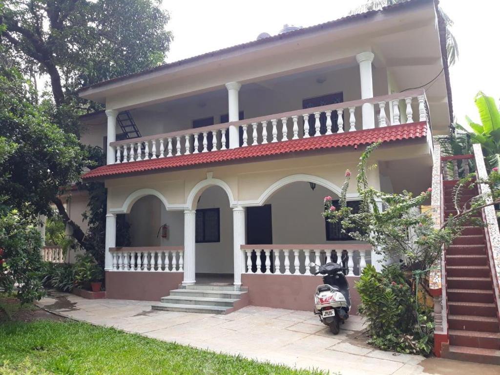 a motorcycle parked in front of a house at Agnelo's Holiday Homes in Candolim