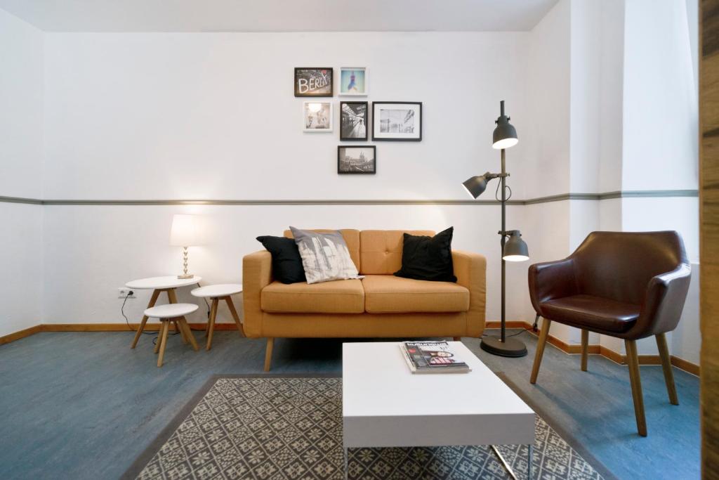 ein Wohnzimmer mit einem Sofa und einem Stuhl in der Unterkunft Old Town Hostel in Berlin