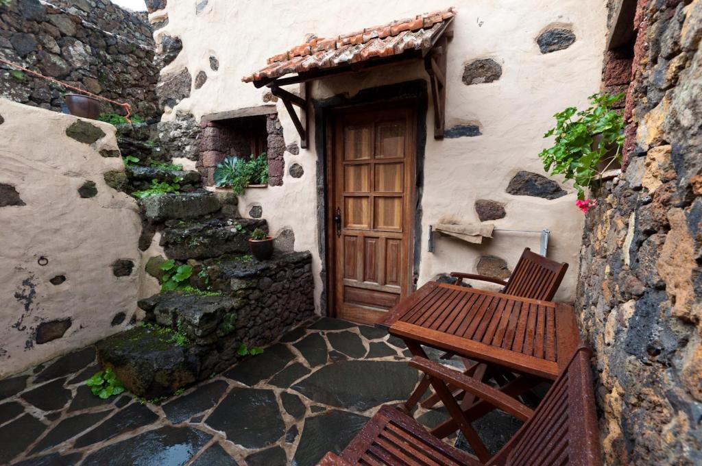 un edificio con una puerta de madera y un banco en Casa Rural Poblado Jirdana, en La Torre