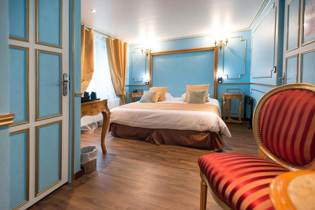 Ault - Villa Aultia Hotel - baie de somme في أولت: غرفة نوم بسرير والجدران الزرقاء وكرسي