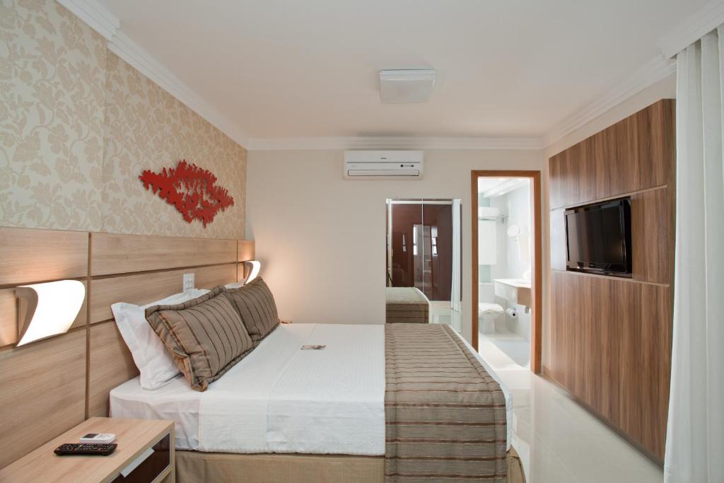a hotel room with a bed and a television at Bristol Jaraguá Hotel Pampulha in Belo Horizonte