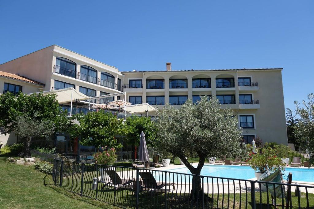 ein Hotel mit einem Pool vor einem Gebäude in der Unterkunft Domaine De Saint Clair Spa & Golf in Saint-Clair