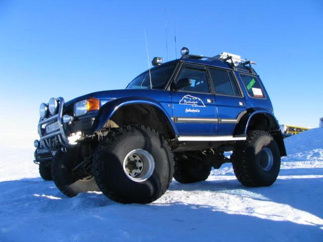 a blue truck is parked in the snow at Fjalladýrð Guesthouse in Modrudalur