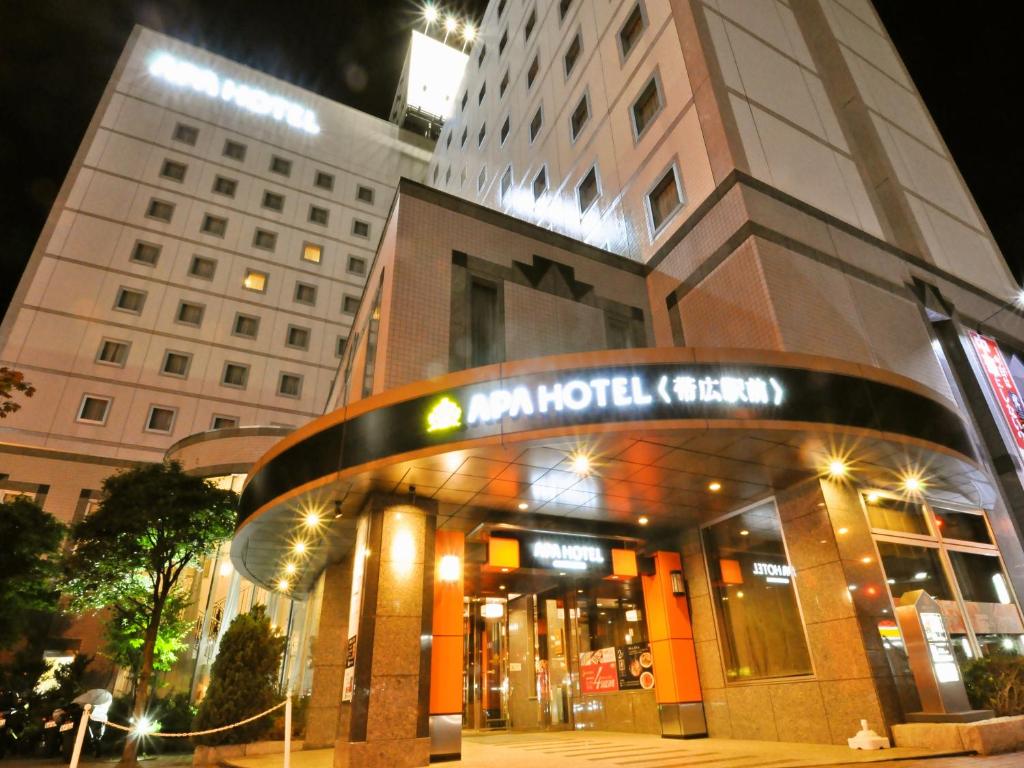 un edificio con un cartel delante en APA Hotel Obihiro Ekimae, en Obihiro