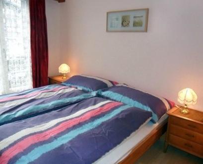 ein Schlafzimmer mit einem Bett und zwei Lampen an einer Kommode in der Unterkunft Pfaffenstöckli in Grindelwald