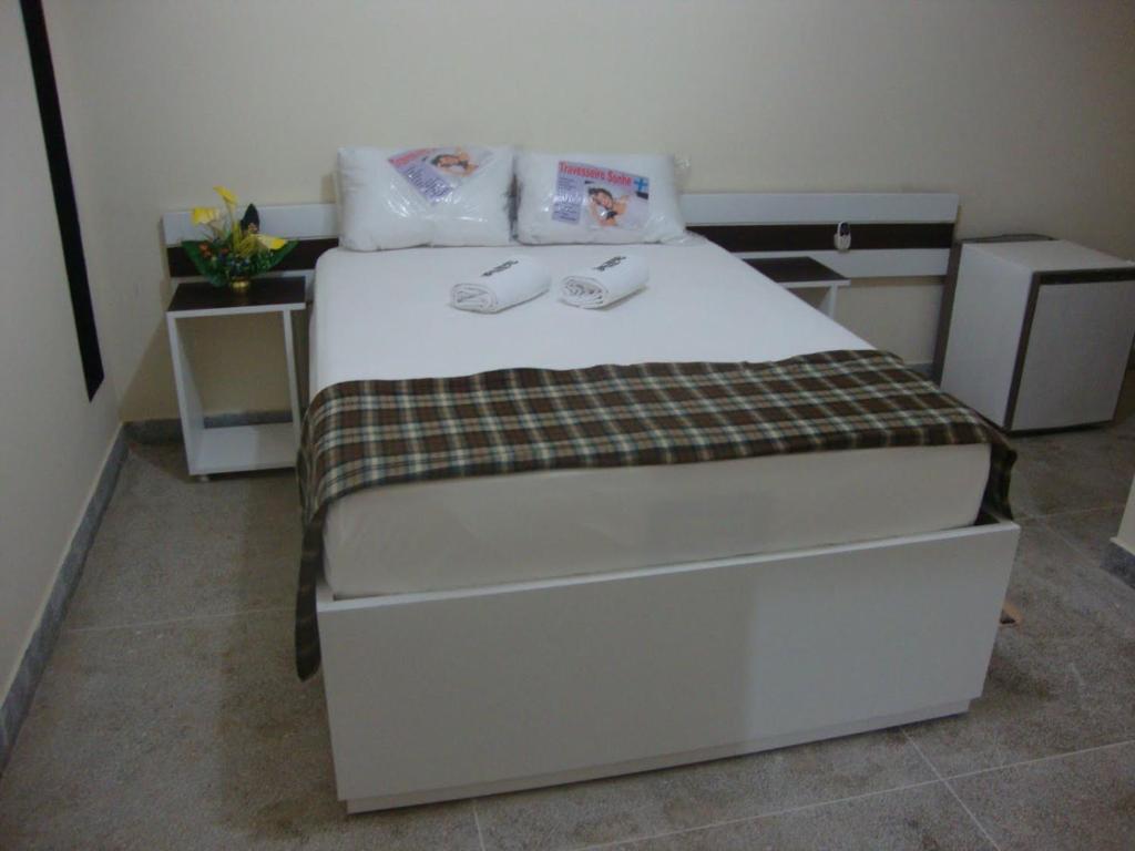 a bedroom with a bed with two towels on it at Hotel Portal Triunfo in Triunfo
