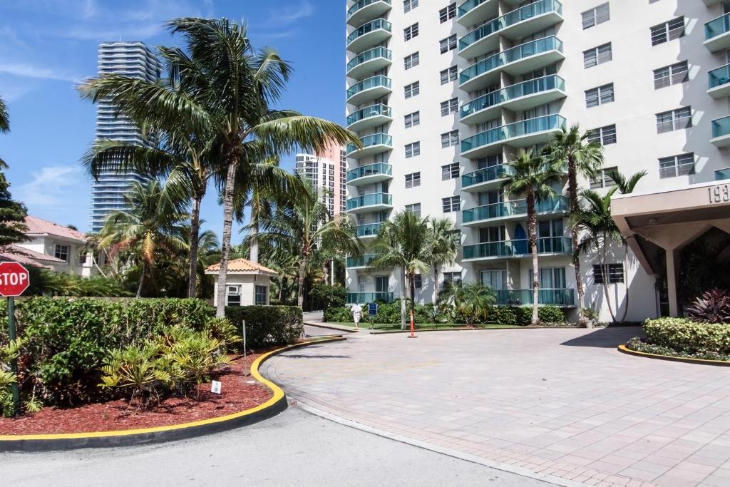 une rue avec des palmiers et un panneau d'arrêt en face d'un bâtiment dans l'établissement Ocean Reserve Piso 4 STR264, à Miami Beach