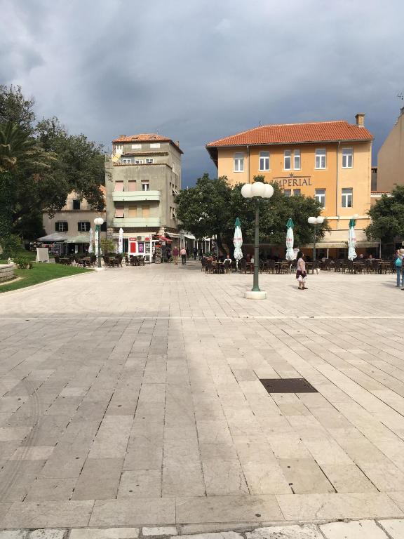 a large plaza with buildings and a street light at Guest house Ribaric in Rab