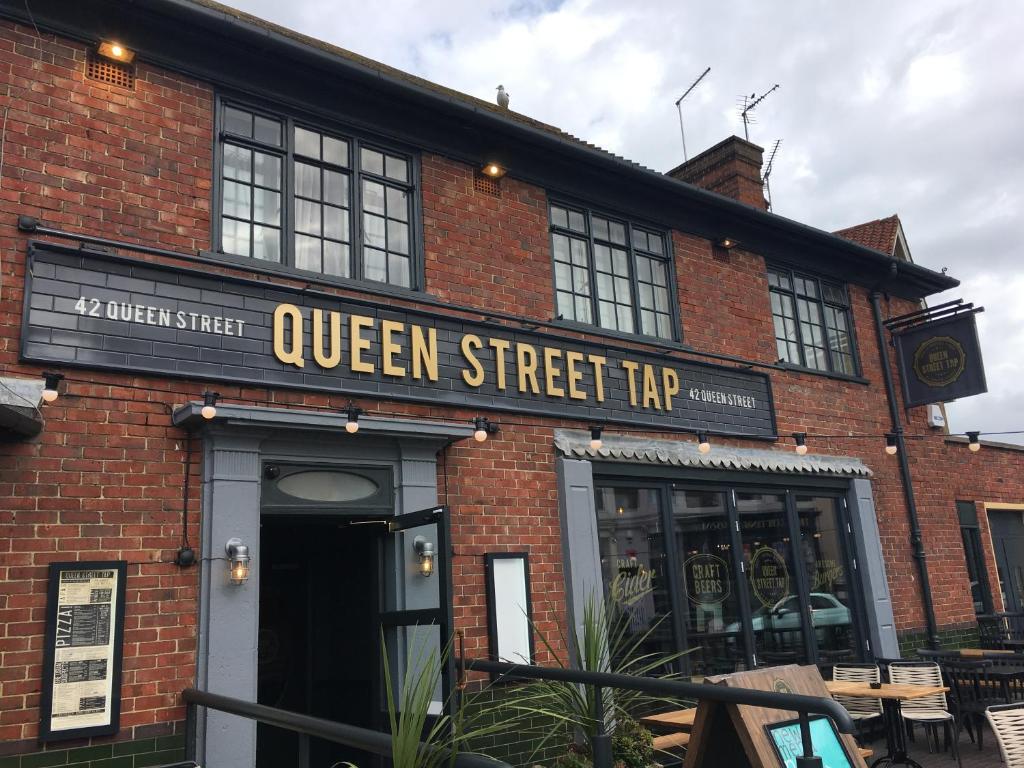 a brick building with a queen street trip sign on it at Queen Street Tap in Deal