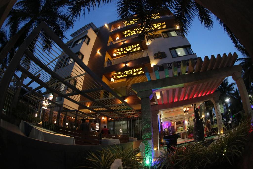 a building with a restaurant in front of it at night at Hotel Hampi International in Hospet