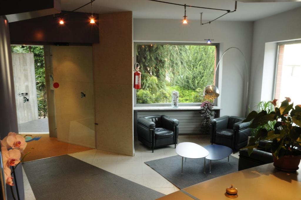 ein Wohnzimmer mit schwarzen Stühlen und einem Fenster in der Unterkunft Hotel Eden in Orbassano
