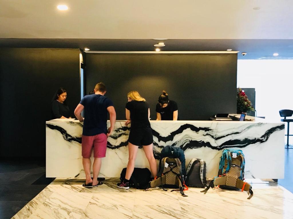 The reception desk, shown with guests checking in and luggage on the floor.