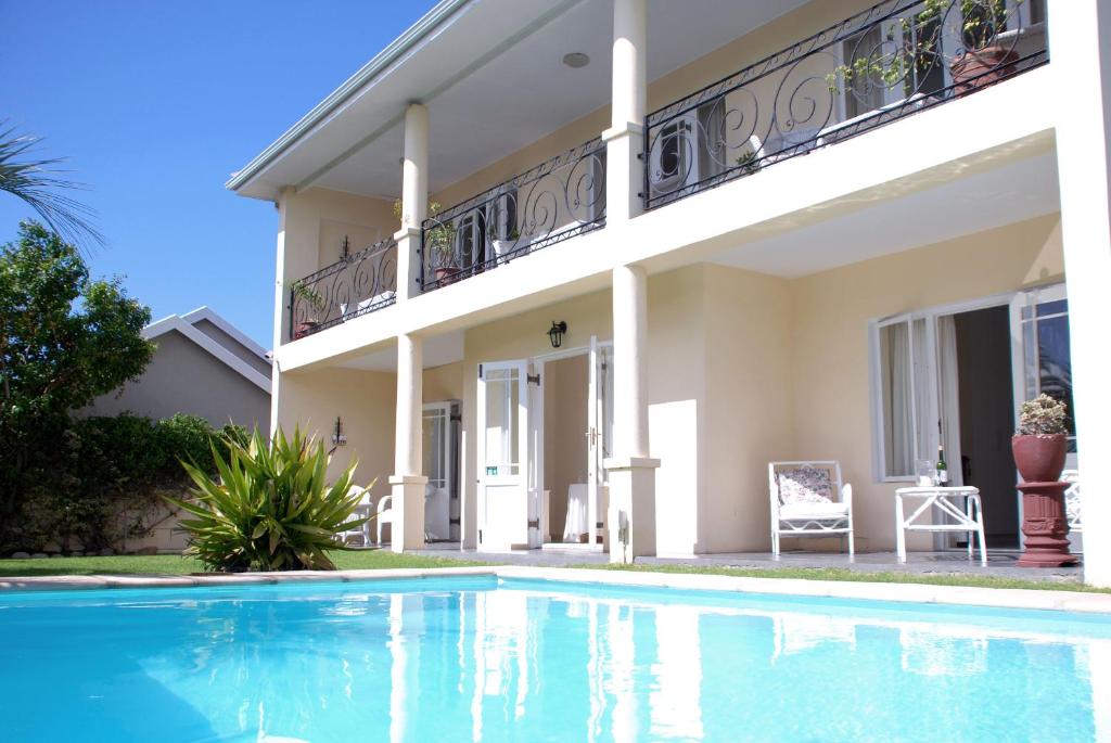 a house with a swimming pool in front of it at Mandalay Guest House Plettenberg Bay in Plettenberg Bay