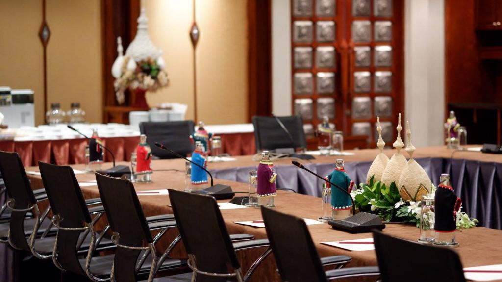 A conference-style dining room set with long tables and decorative place settings.