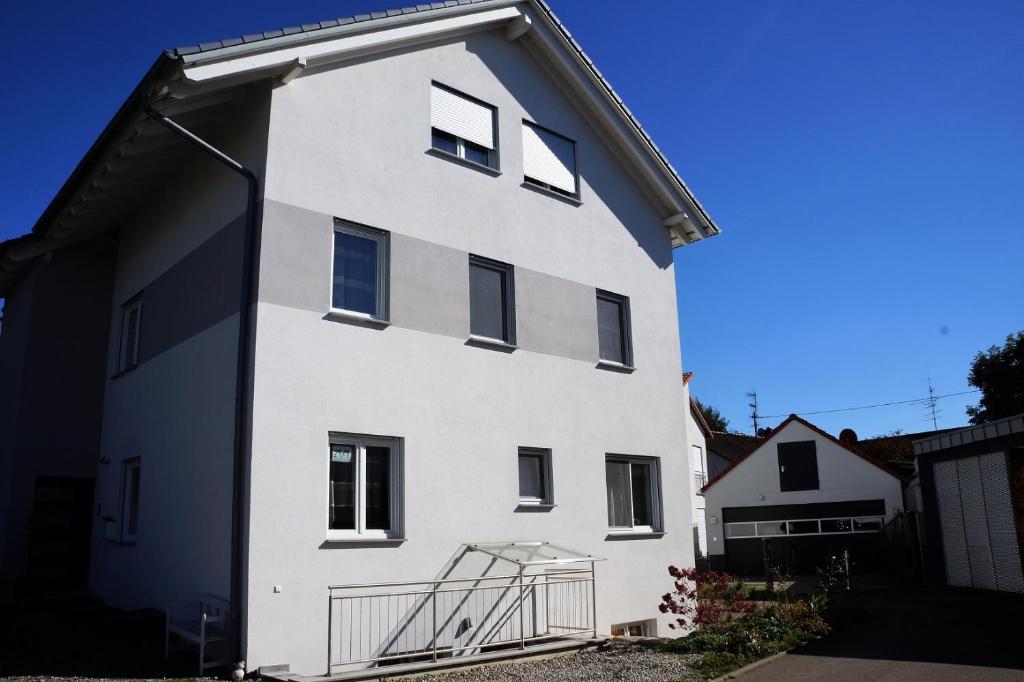 een wit gebouw met ramen aan de zijkant bij Ferienwohnung "Köhler" am Bodensee in Meckenbeuren